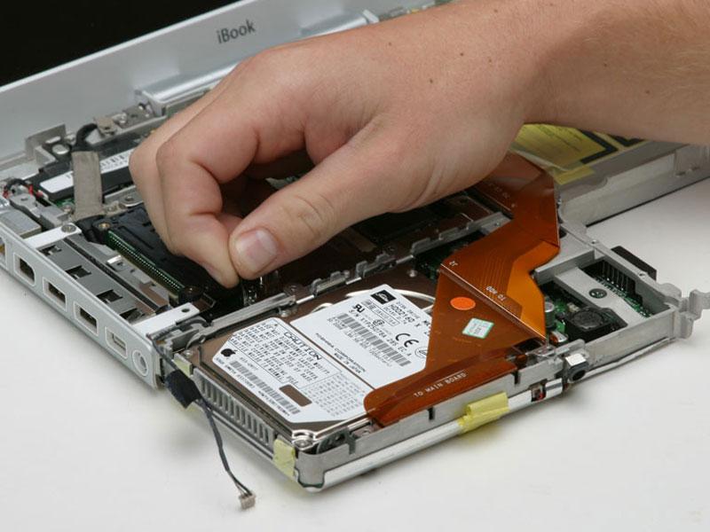 Peel back the black tape and free the microphone cable from the hard drive.