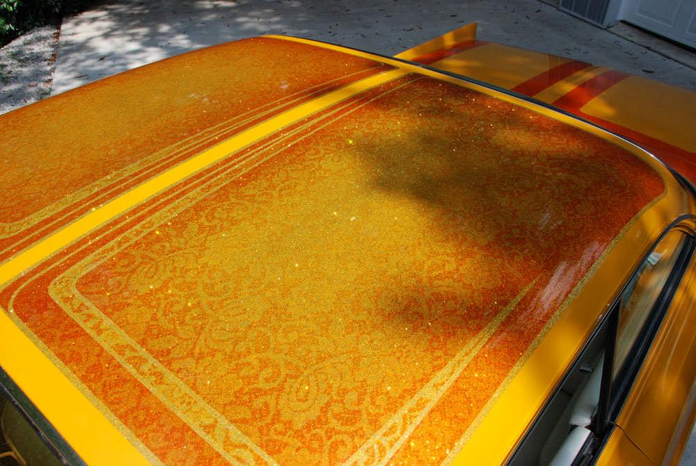 The top has heavy metalflake in gold, tangerine and lime green. It is scalloped as well and has lace sections. The side cove is variegated gold leaf.