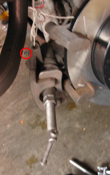 Brake caliper. The bleeder valve is circled in red. 16. Loosen bleeder valve nut with the 11mm wrench ¼ turn. 17.