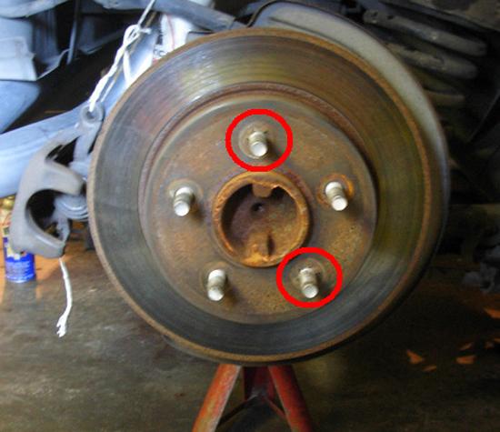 Inside of pad/caliper housing (on backside of the rotor). The 15mm bolts are circled in red. 8. Pry off any rotor retainers that are holding the rotor on the studs.