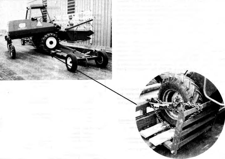 FIGURE 4. Loaded Windrower Illustrating Tie-Down Procedure. (4500 lb) at speeds up to 30 km/h (20 mph). Speeds above 30 km/h (20 mph) are not recommended for implement tires.