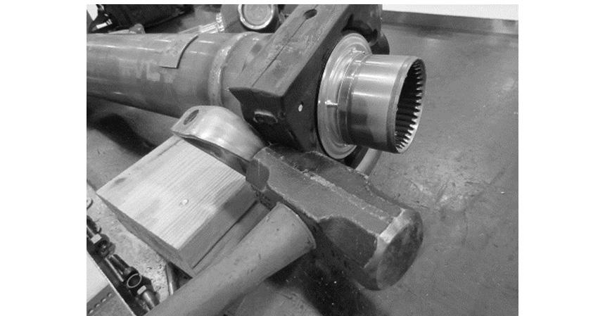 With the driveshaft removed from the truck and on a bench, remove the center bearing bracket from the isolator