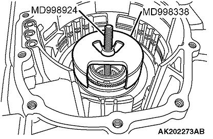 54. Remove the one-way clutch inner race and low-reverse brake piston as follows: 1. Using special tools MD998338 and MD998924, compress the one-way clutch inner race.