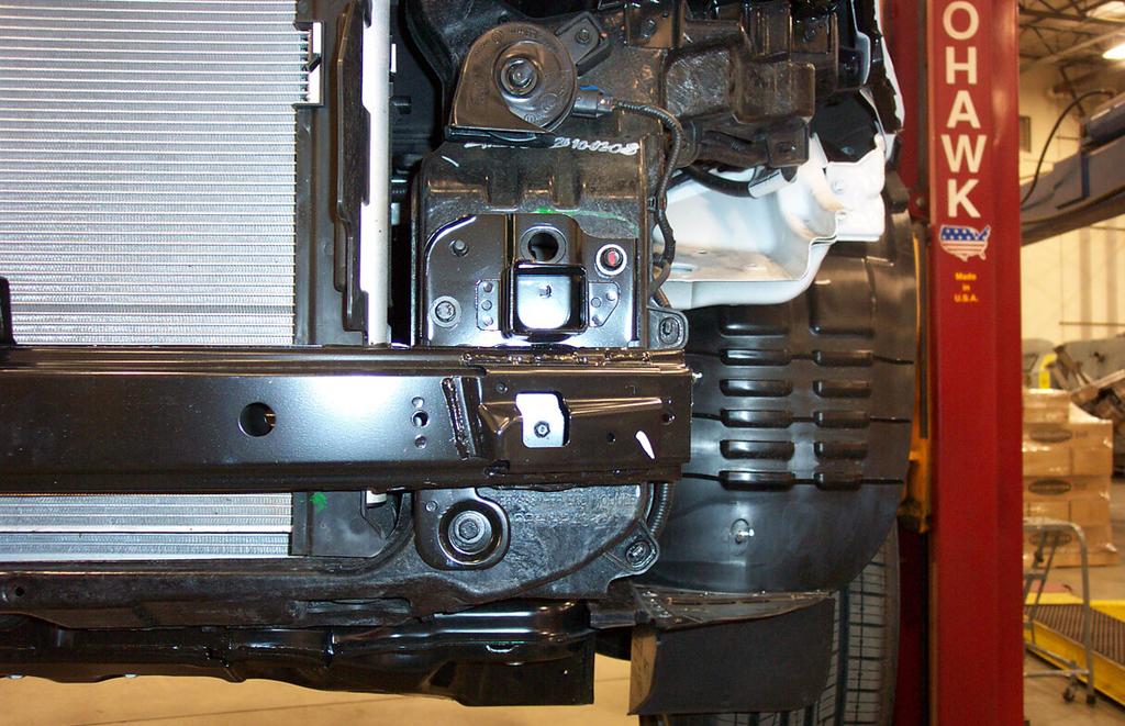 5. Remove seven 12mm (head) bolts and two plastic fasteners attaching the center splash shield to the subframe and radiator support
