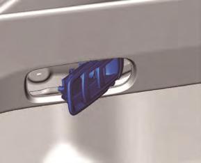 Insert a hand into the back side of the trunk side trim, press the tabs of the remote handle lever in the direction of arrows (1) shown in