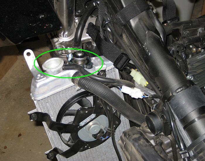 12 10) Once the coolant starts flowing out, go around to the left side of the bike, hold it vertical, and remove the radiator cap from the radiator.