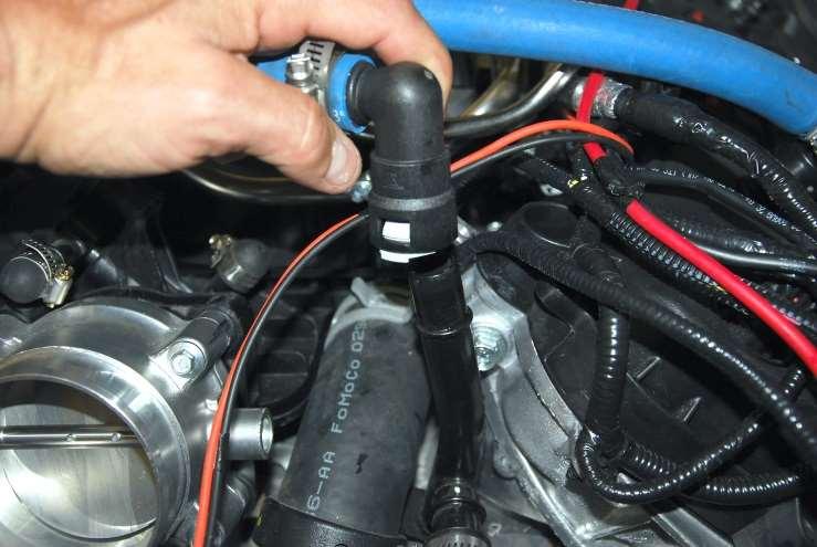 Push the hose onto the top of the tube to the left of the throttle body.