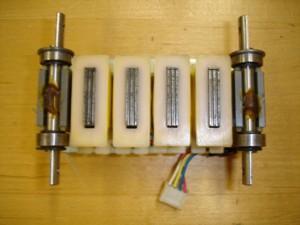 Figure 7. Linear Stepper Motor: Forcer (Bottom View) with Four Windings (in the middle), Two Permanent Magnets (around the shafts), and Four Bearings Figure 8.