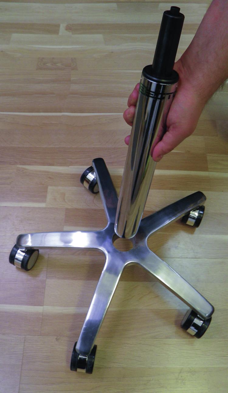 Place the frame upright on the floor and place the gas spring in the central hole of the