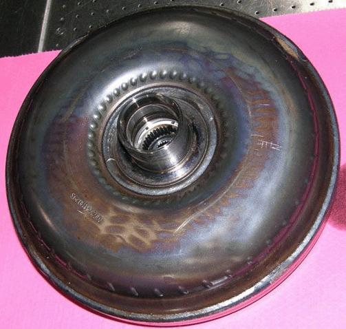 The manufacturing process of the torque converter can cause the hub side to appear blue or darker in color while the lug side is a natural metal color.