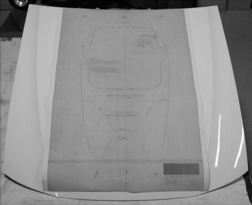Tape template securely to outside hood surface (Figure 2) *During the drilling and cutting process, elevate hood far