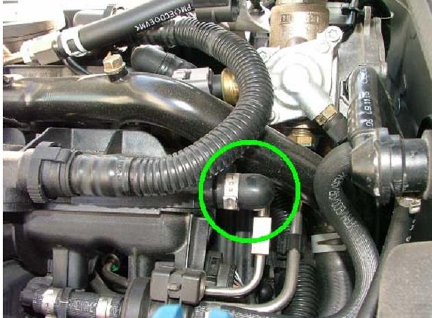 Next, remove the engine cover under the hood. Locate the circled cap.