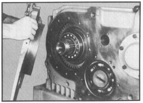 bolts with a chain. (See fig. 79.) The face plate can then be worked out of transfer case housing, supported by the chain hoist.