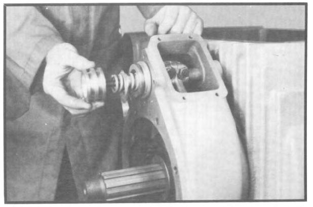 Place piston over threads of shift shaft (depressing spring) with shallower of two grooves facing towards