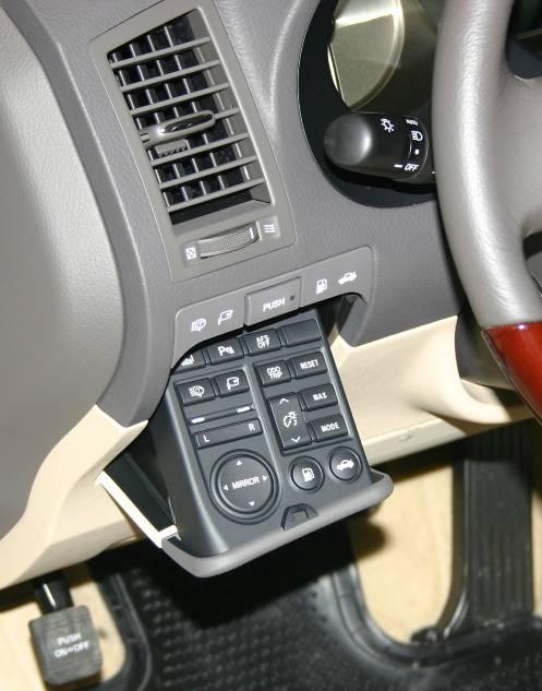 A button that is labeled PUSH, located on the lower left side of the dash, below the left A/C vent opens to reveal a control panel that operates items like the fuel filler door, remote mirror