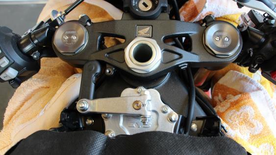 Remove the steering damper cover and the hex nut of the steering damper arm at the triple clamp.