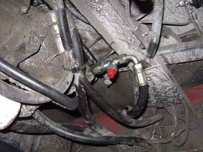Install the run-tee adapter fitting F between the rubber hose and the hydraulic pump (Figure 3b). c.
