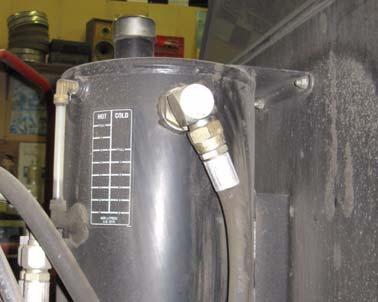 Locate the hydraulic reservoir mounted on the back side of the cab.