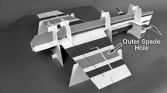 On your building table, place the four top crutches with the feet on them underneath the fuselage in the locations shown.
