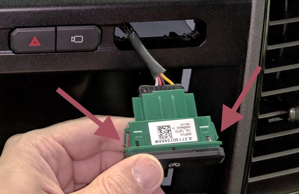 9. Press the side release clips on the backside of the auto start/stop switch assembly to