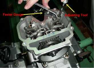 ENGINE INTAKE VALVE CLEARANCE ADJUSTMENT 1. Verify cam lobes are pointed down. 2. Insert a 0.1mm feeler gauge between end of intake valve stem and adjuster screw. 3.
