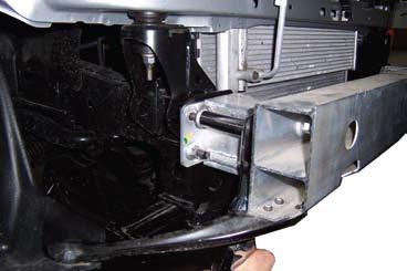 Remove three nuts on each side of bumper and set bumper aside