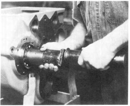 Slip the front bearing (Item 8) over the end of the shaft and into the housing bore. The snap ring on the bearing should be on the outboard side of the bearing. Tap bearing into place (See Fig. 12).