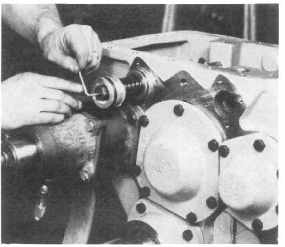Use feeler gauges to measure the distance between the input shaft rear cap (or PTO assembly) and the case housing (See Fig. 33). Add.