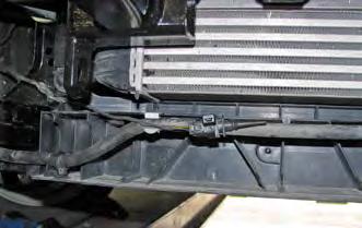Reinstall the metal bumper with the baseplate (white arrow) using all the original hardware removed from the bumper. Reinstall the tubing below the radiator.