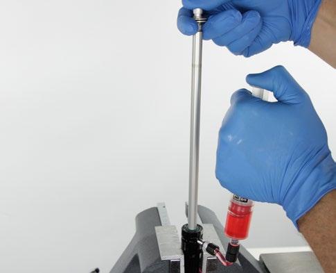 applying opposing pressure on the syringe plunger as the syringe
