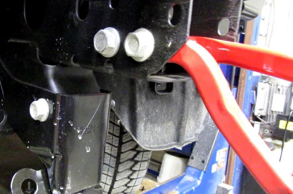 12. On the underside of the vehicle, remove the one (1) bolt holding the bracket using a