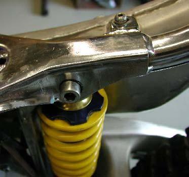Remove the top shock mounting bolt, nut and washer.
