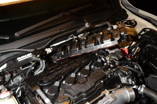 Insert the intake manifold into the space behind the engine, being careful not to disturb the port injection adapter.