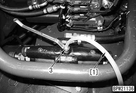 Start the engine to accumulate pressure in the accumulator, and then stop the engine. 2. Remove inspection cover (1) of the front frame.
