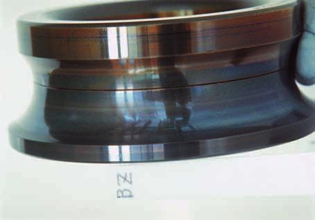 Poor lubrication Oil stain due to a reaction with lubricant High temperature Improve the lubrication method Photo 17-1 Inner ring of a cylindrical roller bearing Axial scratches on raceway surface