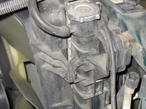 e) Remove the bolt securing the radiator shroud to the radiator as shown. Note: 03-04.