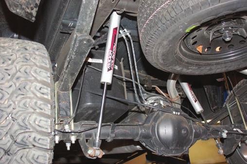 Remove tire and wheels. 7. Lightly support the differential with a floor jack. 8. Remove the stock shock absorbers using a 21mm wrench. Retain the hardware for reuse. 9.