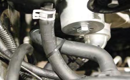 Using a pair of pliers to squeeze the stock spring clamp, rotate the coolant line shown where it