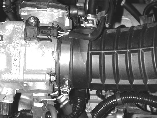 Remove the valve cover breather hose from the air inlet pipe by compressing the flanges
