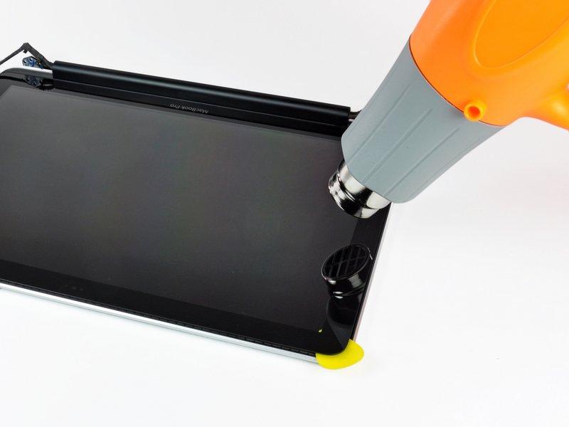 Step 20 Use a heat gun to soften the adhesive under the black strip along the left side of the front glass panel.