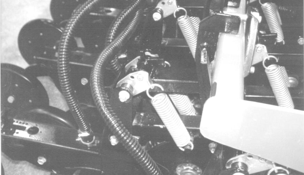 To adjust wing down pressure, 1. Check that in-cab rocker switch is on and selector valve is turned to field position. Refer to Figure 2-9, page 17. 2. Lower implement so openers are on ground. 3.
