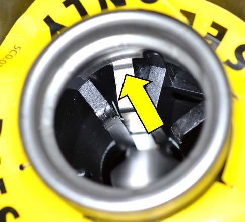 Verify the locking tab on the flap insert is fully seated behind the ring of the filler neck <arrow>.