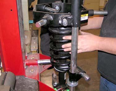 b. Using spring compressors, carefully compress coil spring until coil spring is free from shock absorber.
