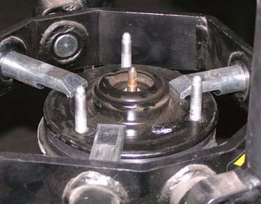 Remove nut, upper plate, spring locator, and shock absorber from coil spring. Plate Nut Locator d.
