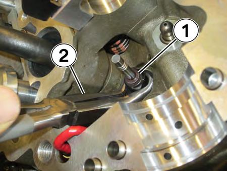 27. Remove the valve seal (1) with the seal pliers (2) included in