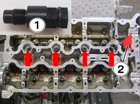 16. Screw four of the black plastic spark plug TDC tools (1) into each of the spark plug holes (see arrows) to avoid debris from falling into the cylinders.