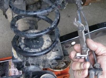 Lower the axle with the jack and remove the front coil springs.