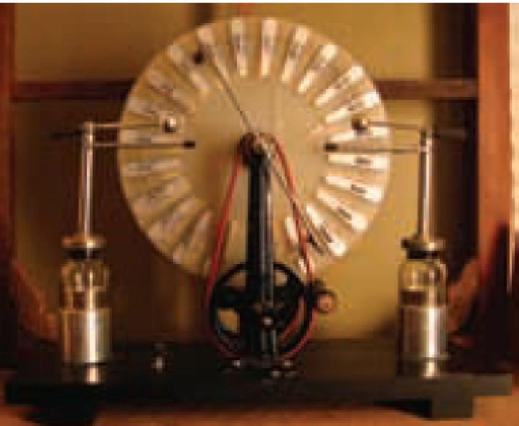 A Wimshurst machine creates charges on two slowly rotating disks with metal strips placed around the disks.