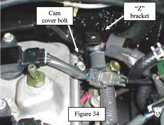 80. Remove the valve cover bolt and sealing washer from the rear hole on the driver side of the valve cover. See Figure 34.