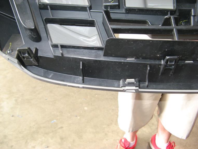 6. Use a flat head screw driver to unclip the vehicle grill